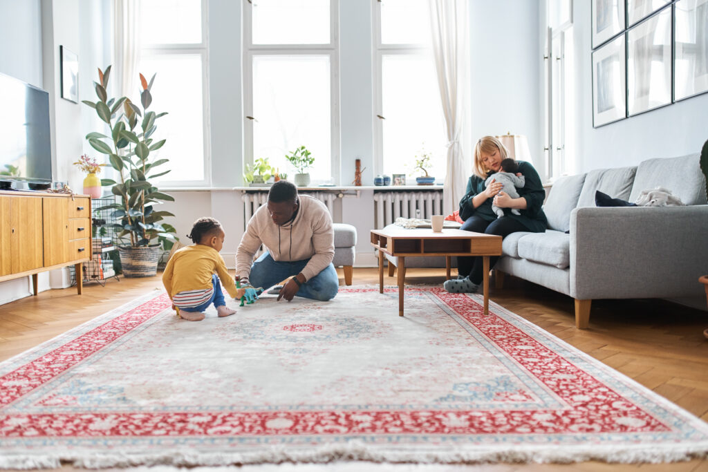 Father playing with son and mother taking care of son at home